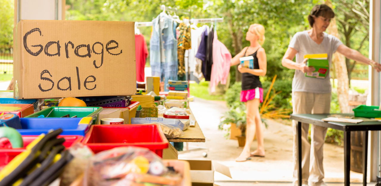 Consumerism:  Adult women buying at a yard sale in suburbs