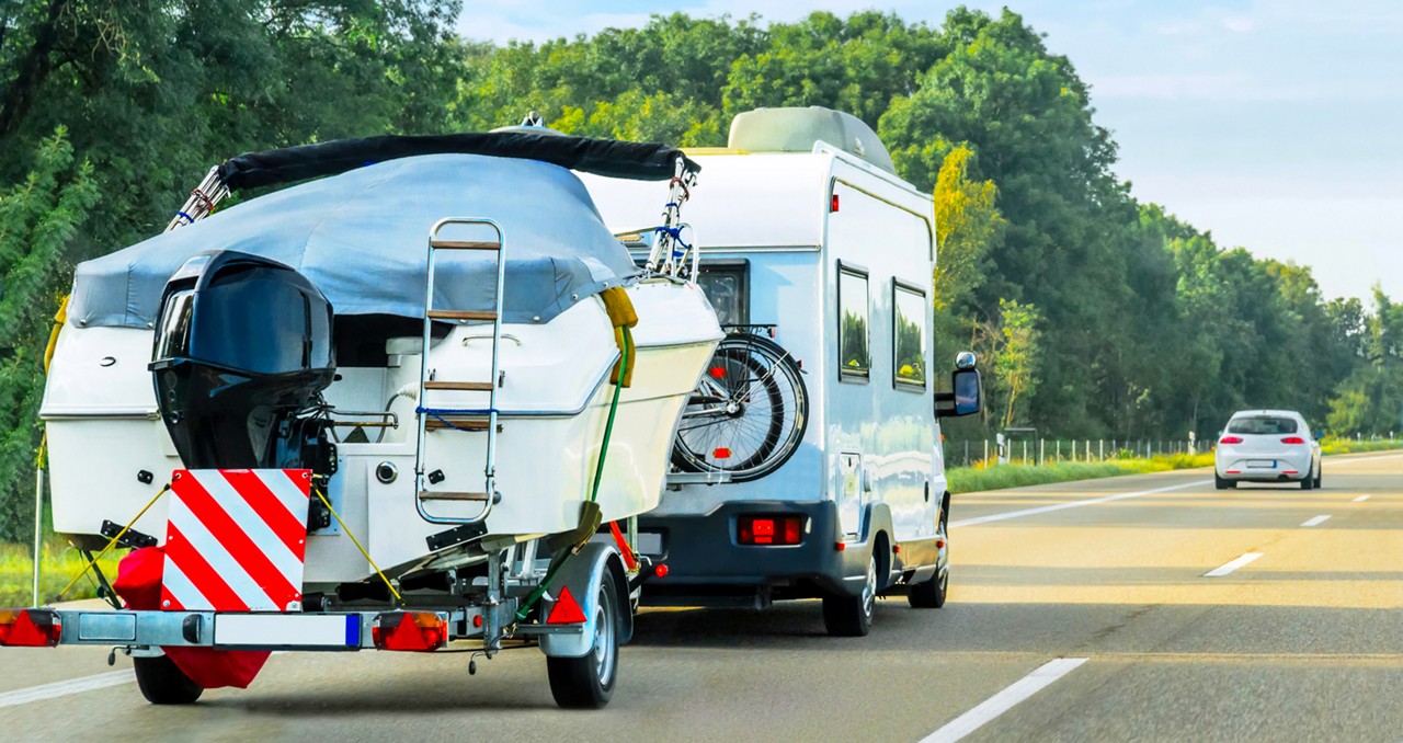 Vacation trip with Caravan Car and trailer with motorcycles on road of Switzerland. Camper and Summer drive on highway. Holiday journey in rv motorhome for recreation. Motor home motion ride.